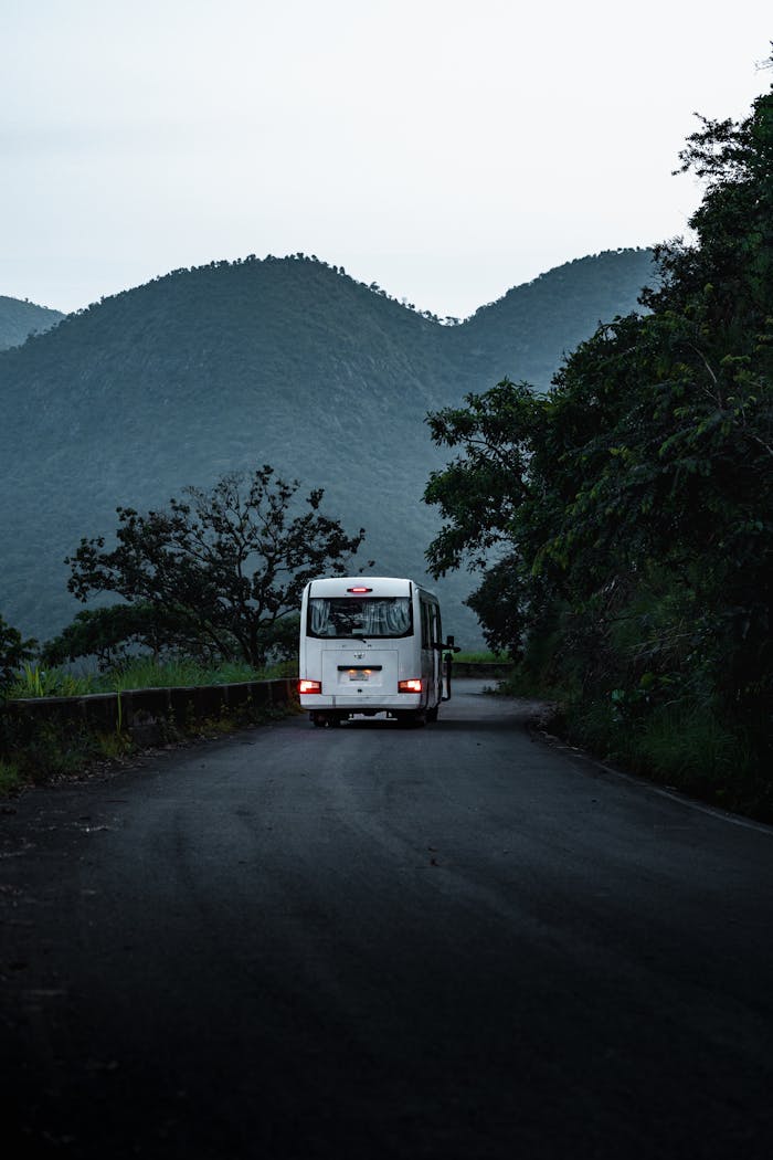 A bus travels a winding road through lush Nigerian hills, capturing a serene travel moment.