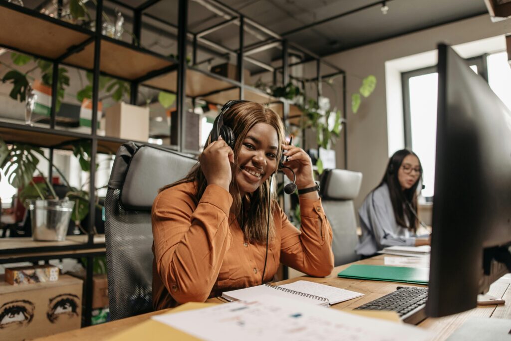 Smiling call center agents working together with headsets in a contemporary office space.